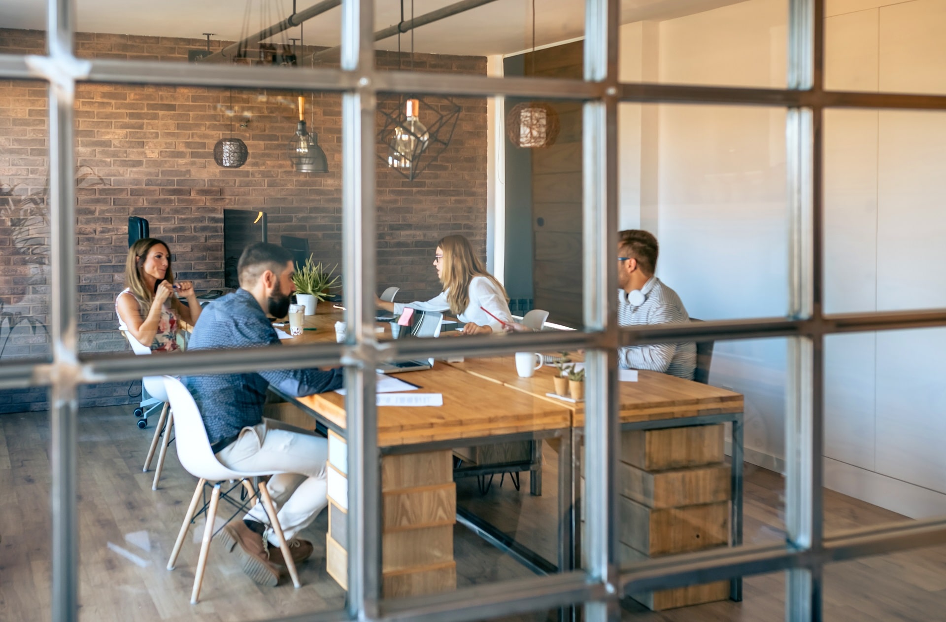 Interior oficina con una reunión de trabajadores. MENTORAES ofrece coaching ejecutivo y empresarial