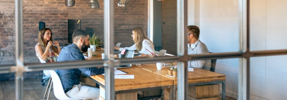 Interior oficina con una reunión de trabajadores. MENTORAES ofrece coaching ejecutivo y empresarial